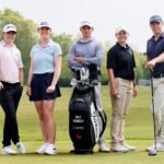 Five golfers (two women, three men) pose with golf bags on a green course, clubs at their sides, trees in the background.