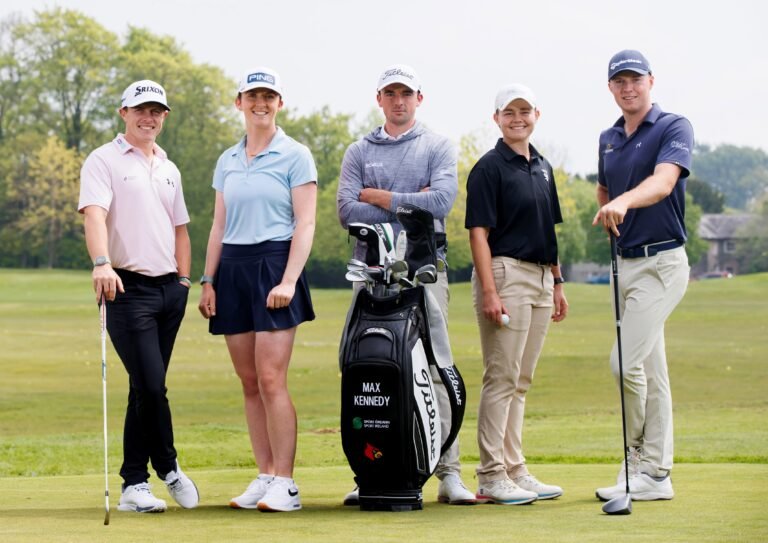 Five golfers (two women, three men) pose with golf bags on a green course, clubs at their sides, trees in the background.