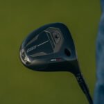 Close-up of a black golf driver head against a green background, showing the GTS300 branding on the sole