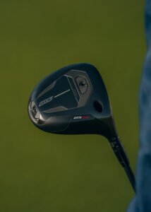 Close-up of a black golf driver head against a green background, showing the GTS300 branding on the sole