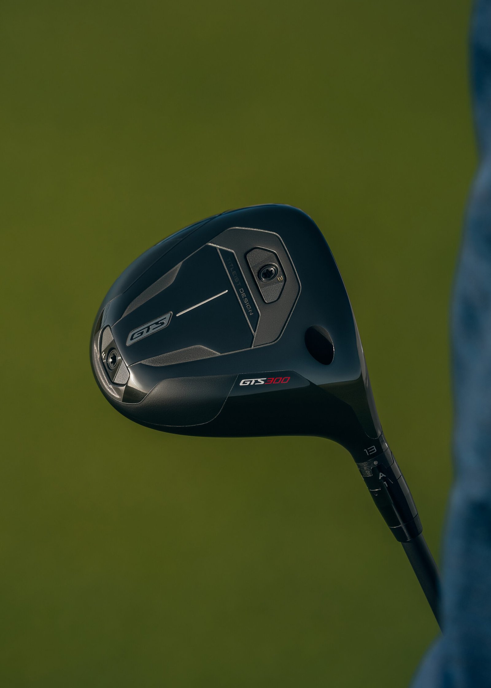 685885-NEW_GTS300_mini_driver_002-66f810-original-1782844029 - Talk Golf Ireland Close-up of a black golf driver head against a green background, showing the GTS300 branding on the sole
