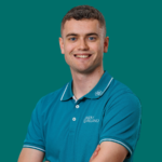 Portrait of a smiling man in a teal polo shirt with the Golf Ireland logo, arms crossed against a teal background.