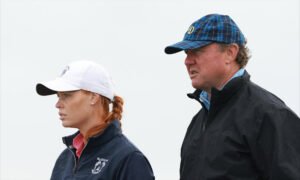 Two adults in outdoor jackets, the woman in a white cap on the left and the man in a blue plaid cap on the right (side profile).