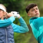 Two young golfers following through after tee shots